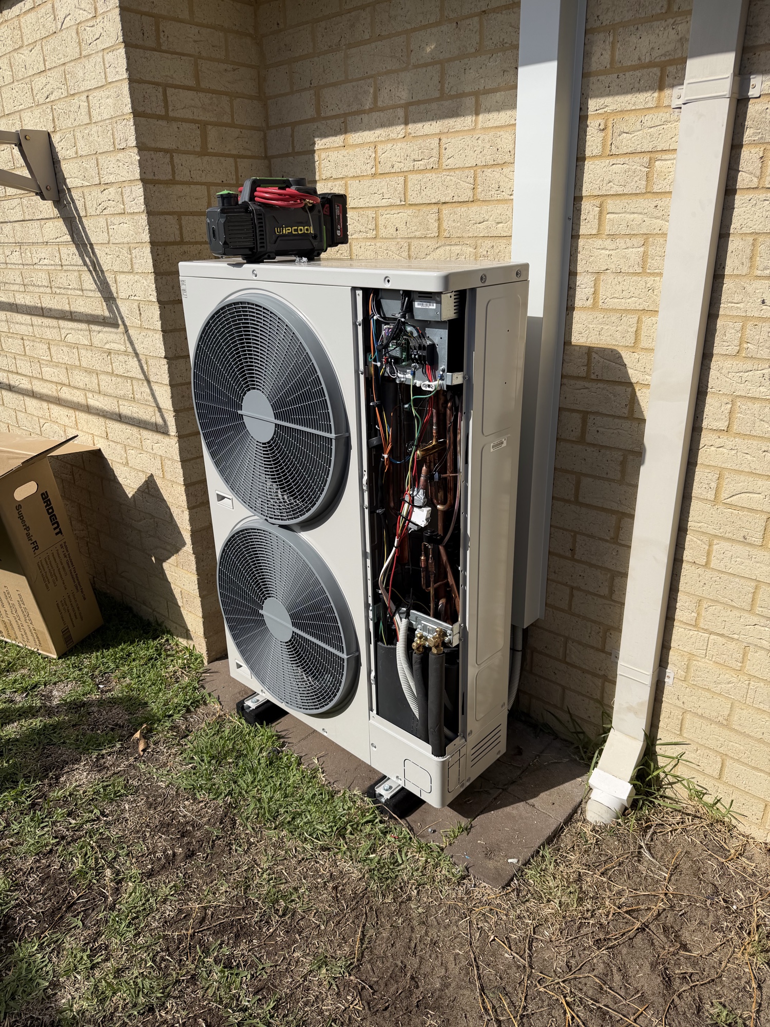 Air conditioning outdoor unit open showing internals being commissioned